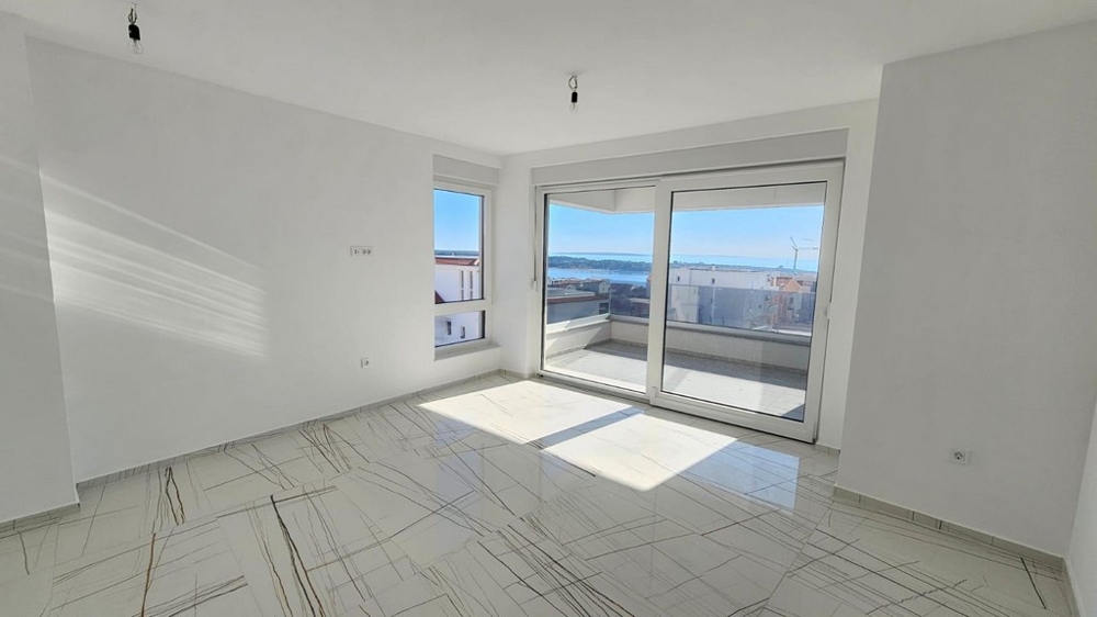 Priestranný obývací priestor s panoramatickými oknami a výhľadom na more