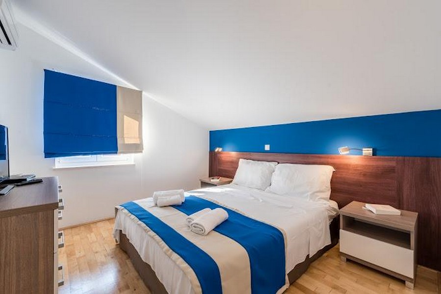 Spálňa s manželskou posteľou a modrými prvkami