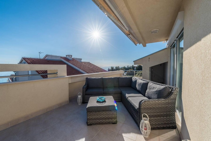 Slnečná strešná terasa s posedením a výhľadom na more