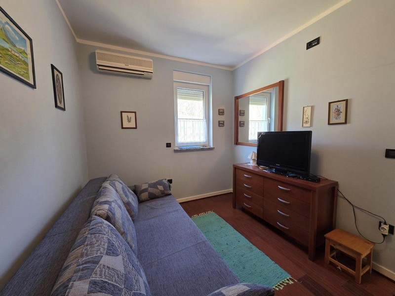 Spálňa s pohovkou, komodou a televíziou