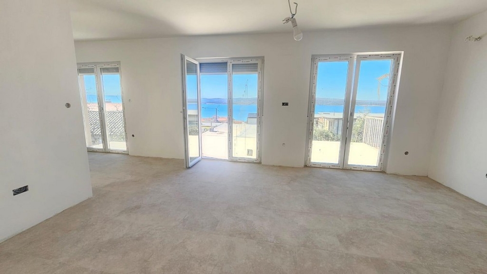 Svetlom zaliata obývačka apartmánu A3604 s krásnym výhľadom na more.