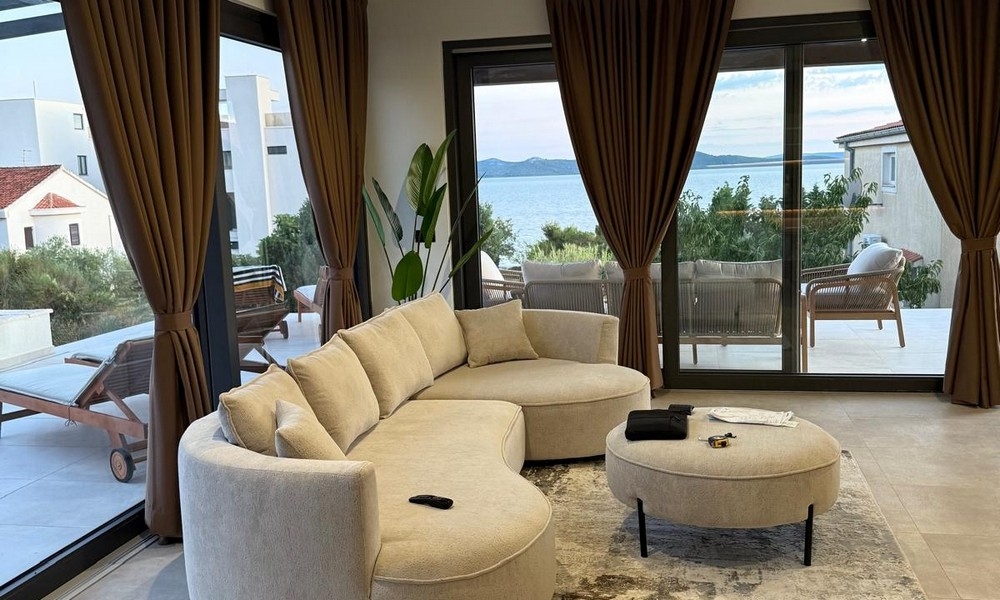 Obývacia izba s veľkým oknom a výhľadom na more