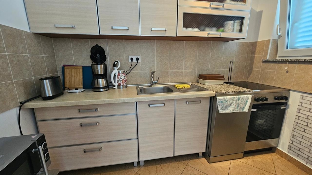 Kuchyňa s elektrospotrebičmi a hornými a spodnými skrinkami