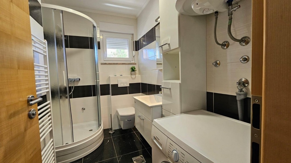 Kúpeľňa so sprchovacím kútom a práčkou