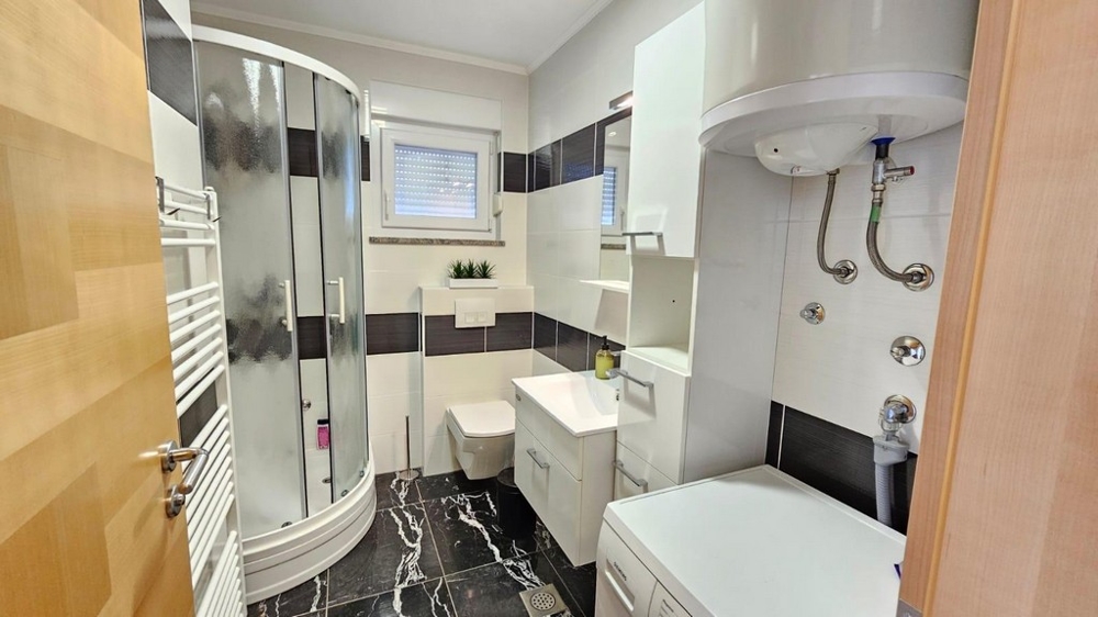 Kúpeľňa so sprchovacím kútom a práčkou