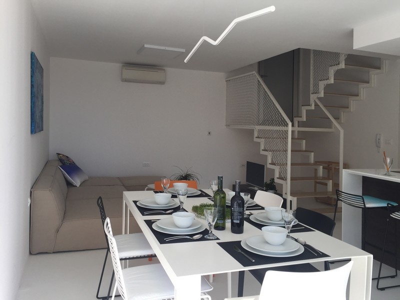 Obývacia izba so sedačkou, jedálenským kútom a schodiskom na galériu