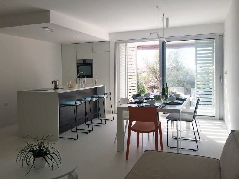 Svetlá kuchyňa s barovým kútom a jedálenským kútom pri okne