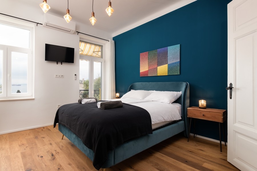 Spálňa s výhľadom na more a tmavomodrou stenou