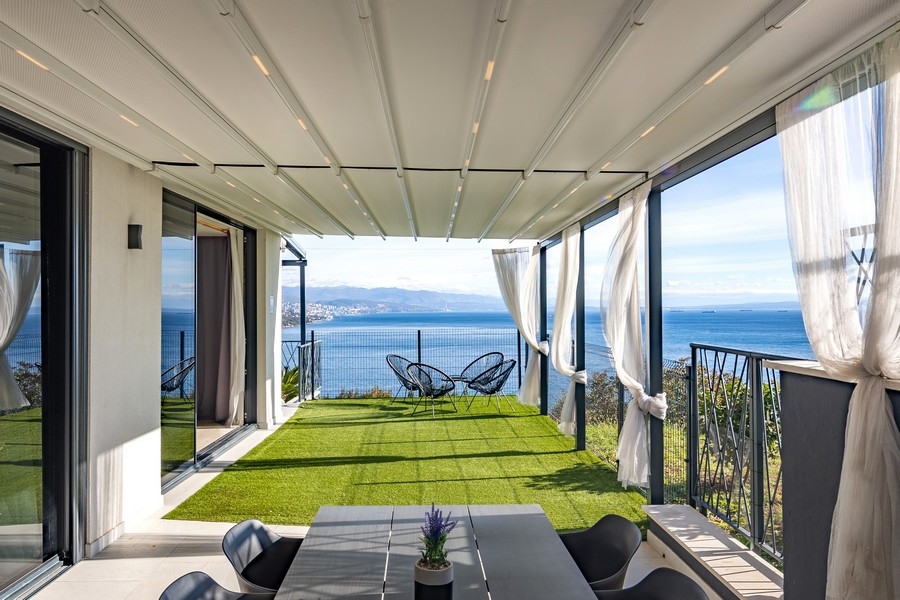 Krytá terasa so záhradou a panoramatickým výhľadom na more.