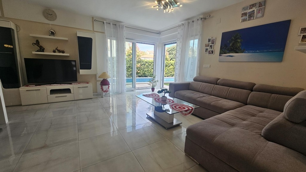 Svetlá obývacia izba s rohovou pohovkou a TV