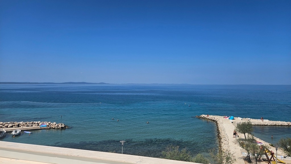 Panoramatický výhľad na more so zátokou na kúpanie a mólom v Zatone