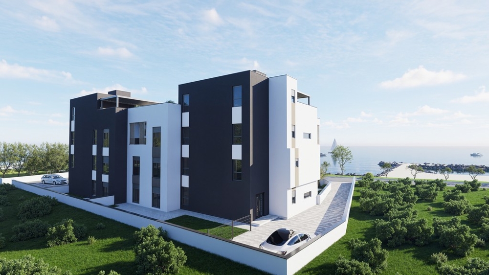 Pohľad zozadu na modernú novostavbu s parkovacími miestami a výhľadom na more