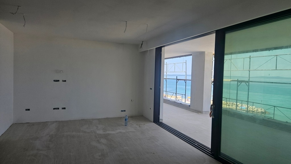 Interiér v škrupine s veľkými posuvnými oknami a výhľadom na more