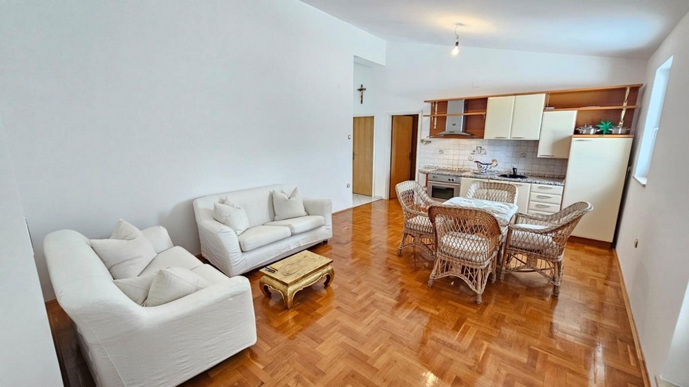 Obývacia izba s pohovkou, ratanovými stoličkami a kuchyňou