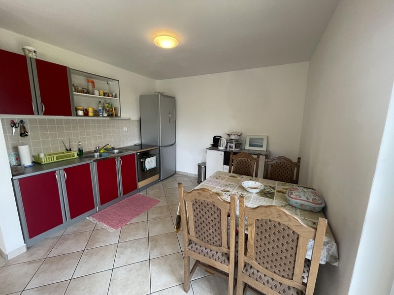 Kuchyňa s jedálenským stolom a červeným čelom