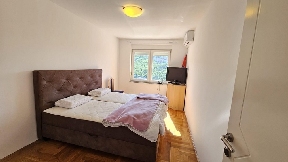 Spálňa s manželskou posteľou a výhľadom na okno