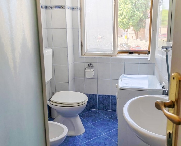 Kúpeľňa s oknom a modrými dlaždicami