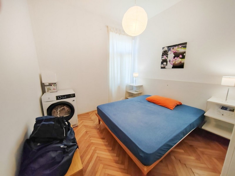 Spálňa s manželskou posteľou a práčkou