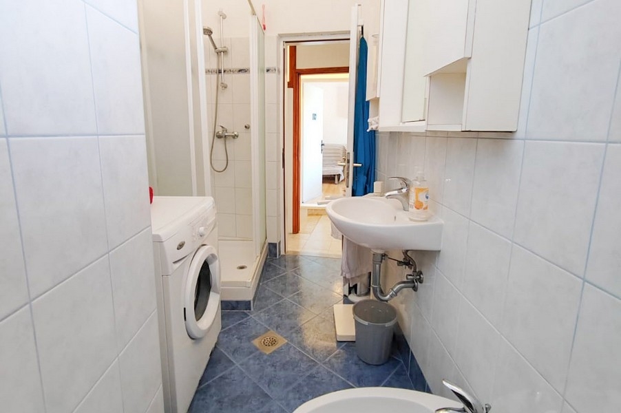 Kúpeľňa so sprchovacím kútom a práčkou