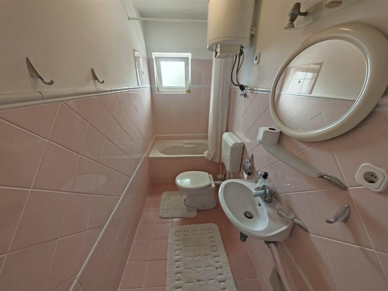 Kúpeľňa s vaňou a ružovými obkladmi