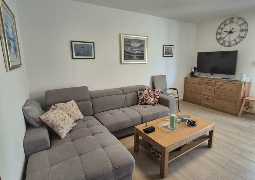 Obývacia časť so sivou rohovou pohovkou a konferenčným stolíkom