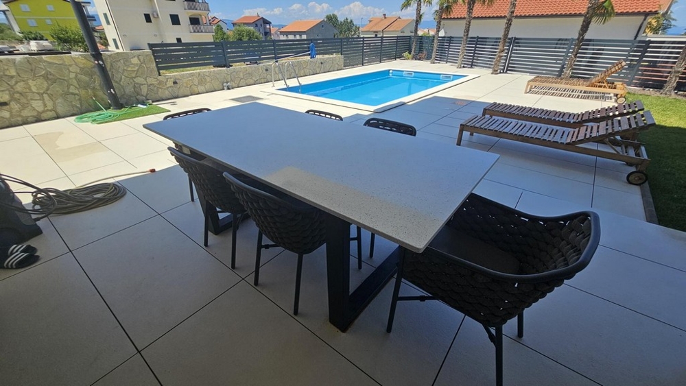 Terasa s jedálenským stolom, výhľadom na bazén a ležadlami