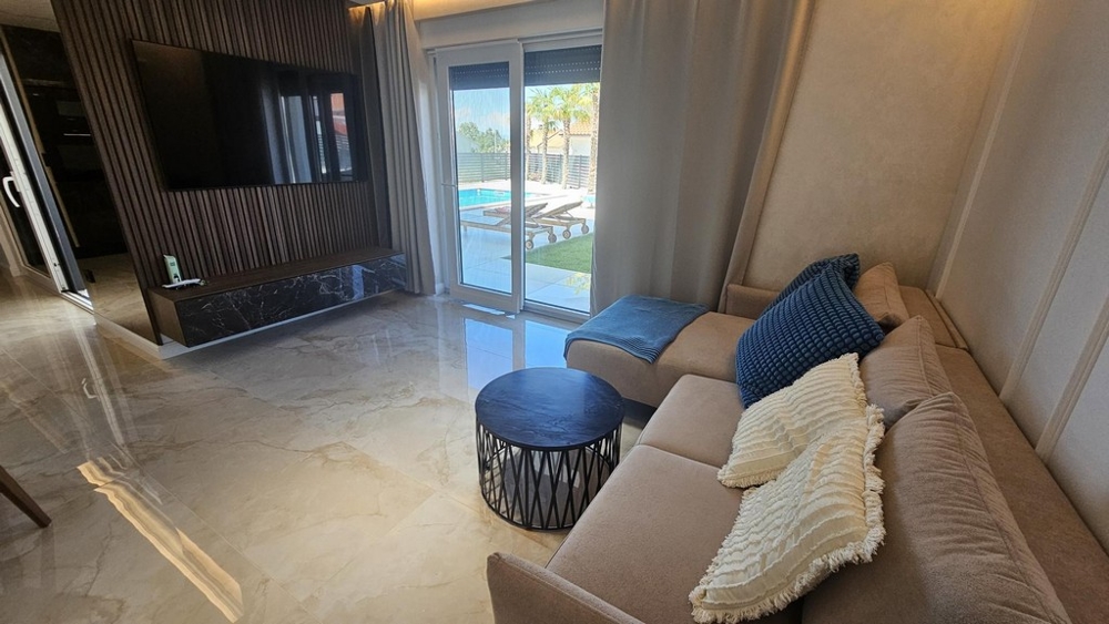 Obývacia izba s pohovkou, konferenčným stolíkom a vstupom na terasu