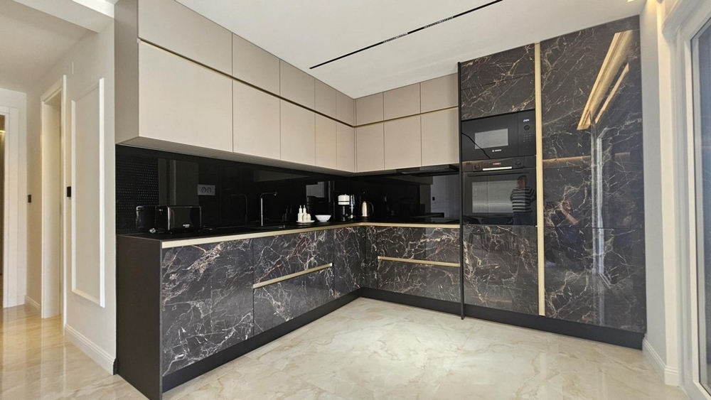 Moderná kuchynská linka s mramorovými čelami a vstavanými spotrebičmi