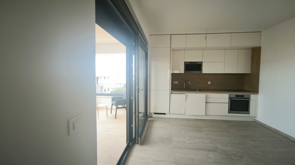 Moderná kuchynská linka so vstavanými spotrebičmi a vstupom na terasu