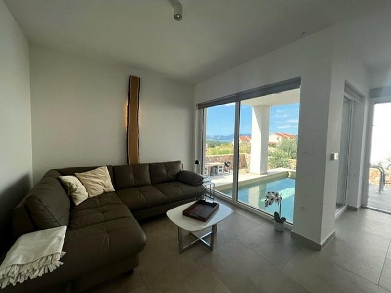 Obývacia izba s pohovkou a výhľadom na bazén v nehnuteľnosti A3723, ostrov Krk