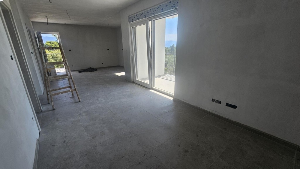 Obývacia izba s terasovými dverami a výhľadom na krajinu, nový byt na Krku
