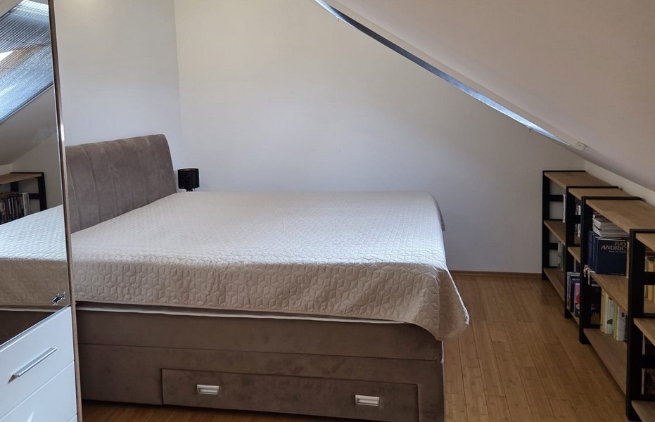 Spálňa s manželskou posteľou pod šikmým stropom