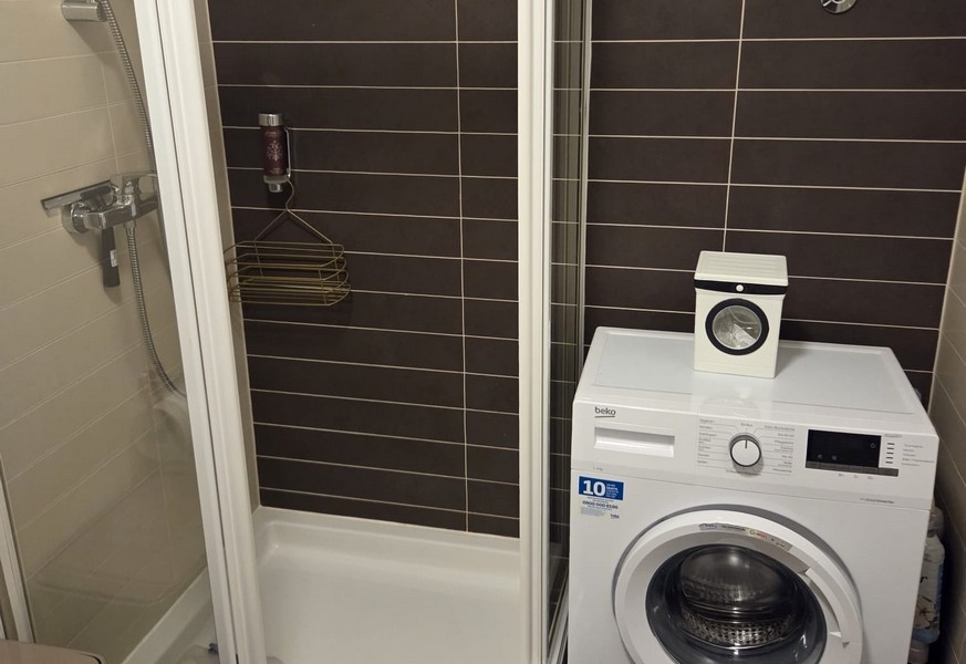 Kúpeľňa so sprchovacím kútom a práčkou