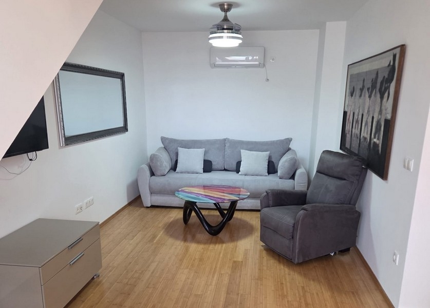 Obývacia izba s pohovkou, kreslom a moderným konferenčným stolíkom