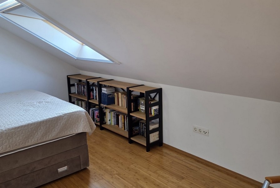 Spálňa so šikmým stropom a policami