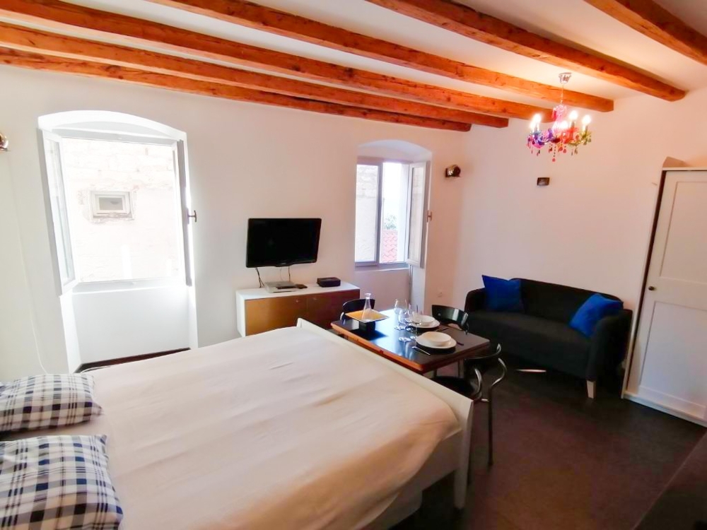 Izba s posteľou a malým obývacím priestorom.