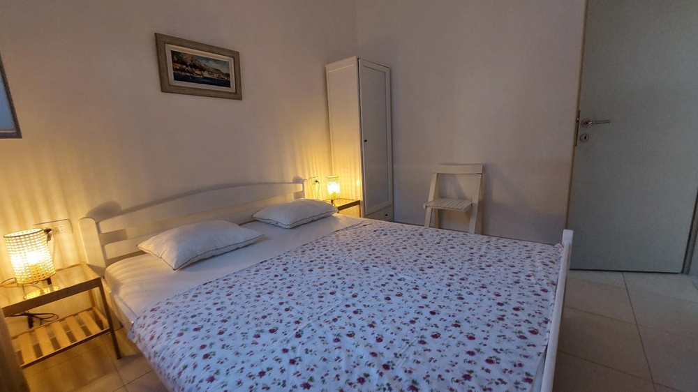 Spálňa s manželskou posteľou a nočnými stolíkmi