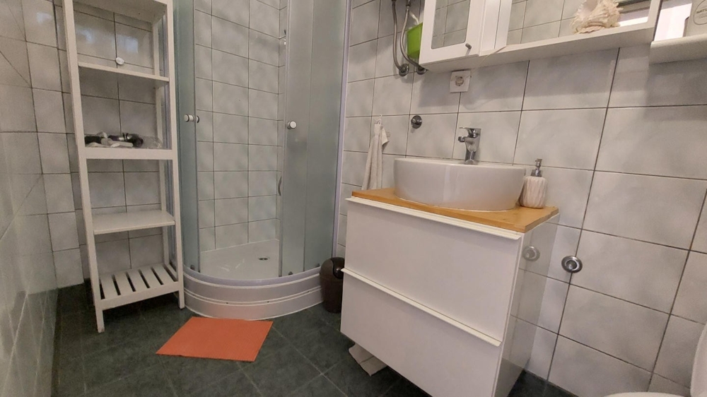 Kúpeľňa so sprchovým kútom, umývadlom a dlažbou