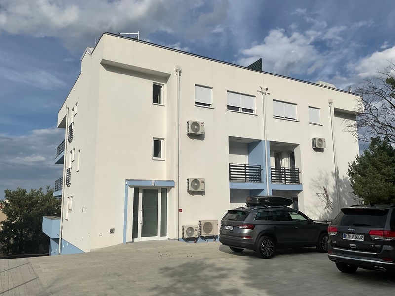 Obytný dom s parkovacími miestami a zaparkovanými autami