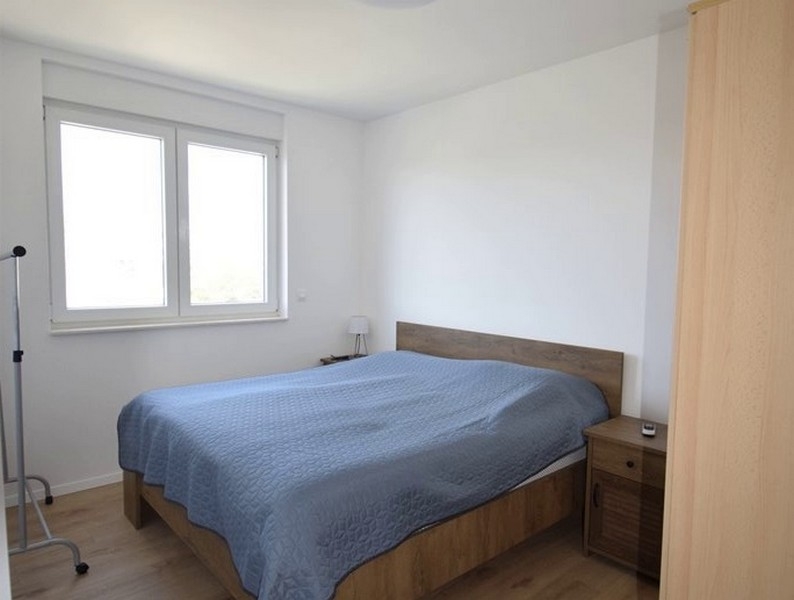 Spálňa s manželskou posteľou a nočným stolíkom