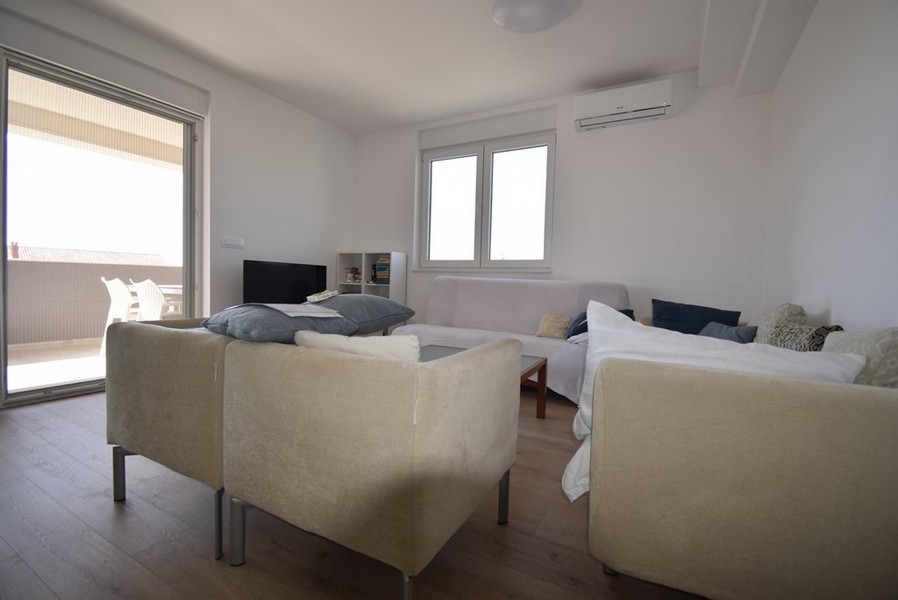 Svetlá obývacia izba s pohovkou a vstupom na terasu