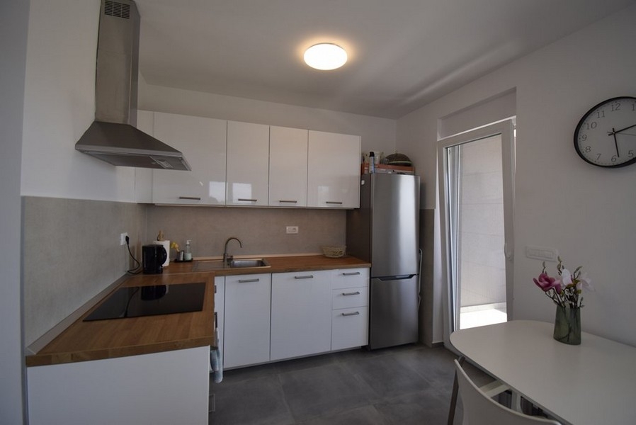 Moderná kuchynská linka so vstavanými spotrebičmi a jedálenským stolom