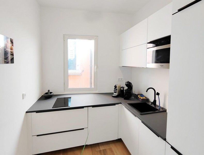 Moderná kuchyňa v bielej farbe s oknom