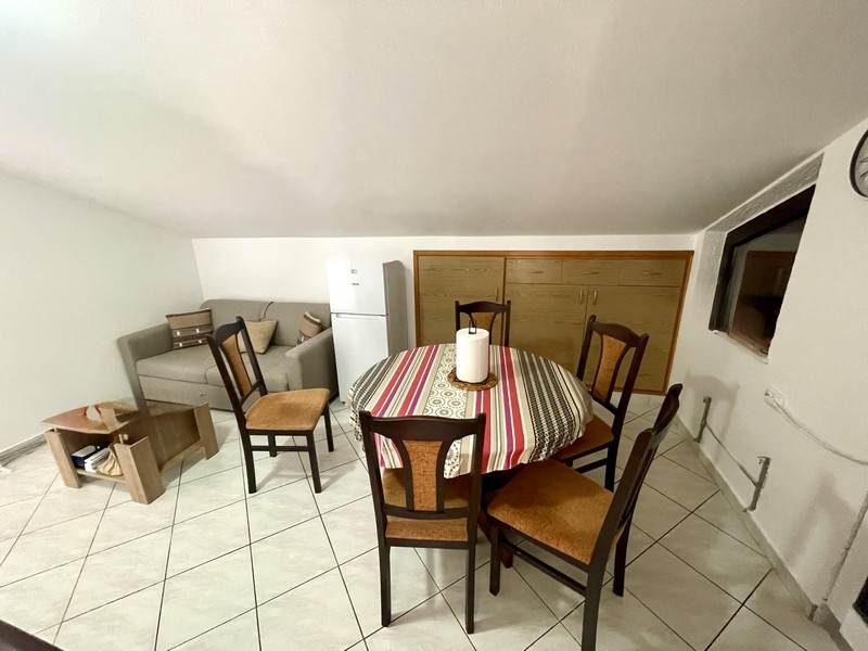 Obývacia a jedálenská časť s pohovkou, chladničkou a stolíkom