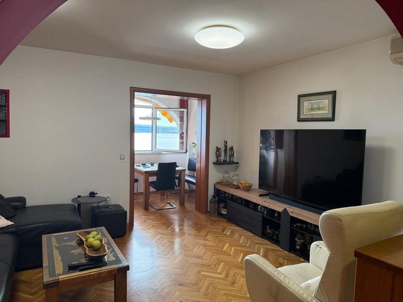 Obývacia izba s TV a výhľadom na more v pozadí