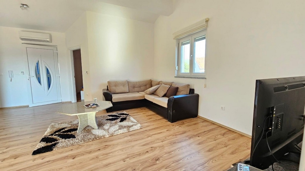 Svetlá obývacia izba s pohovkou a TV