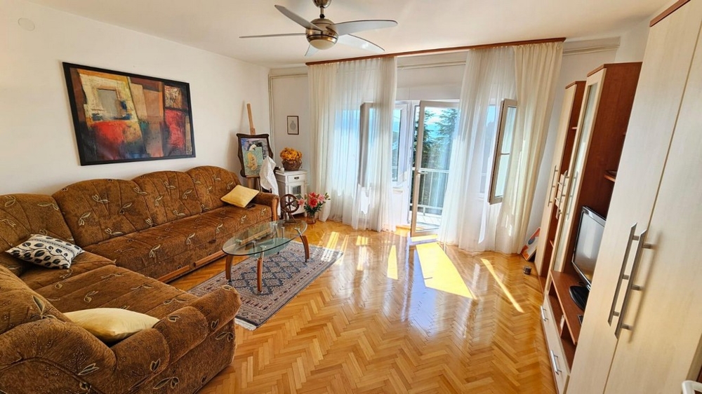 Svetlá obývacia izba s pohovkou a prístupom na balkón
