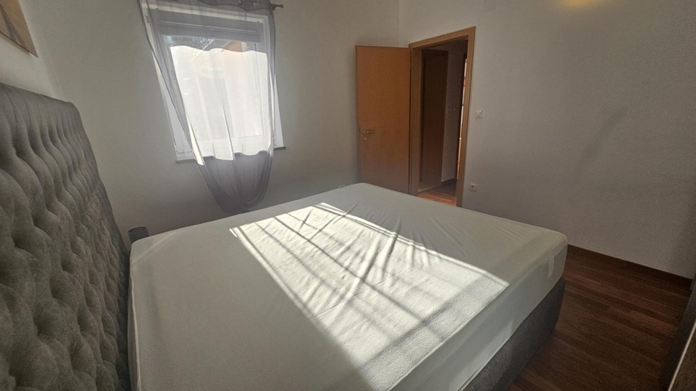 Svetlá spálňa s manželskou posteľou a oknom