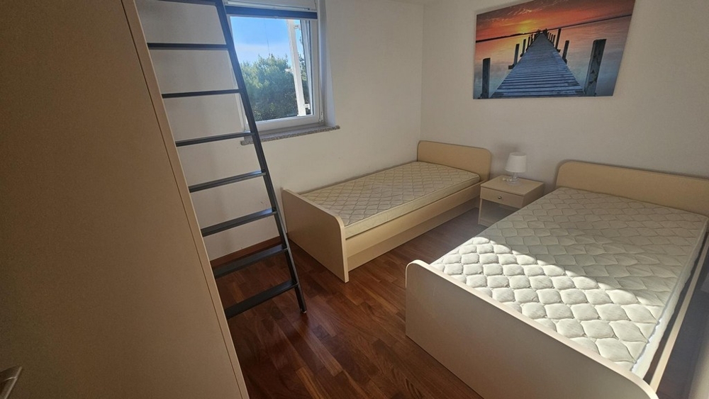 Detská alebo hosťovská izba s dvomi samostatnými lôžkami a rebríkom na galériu