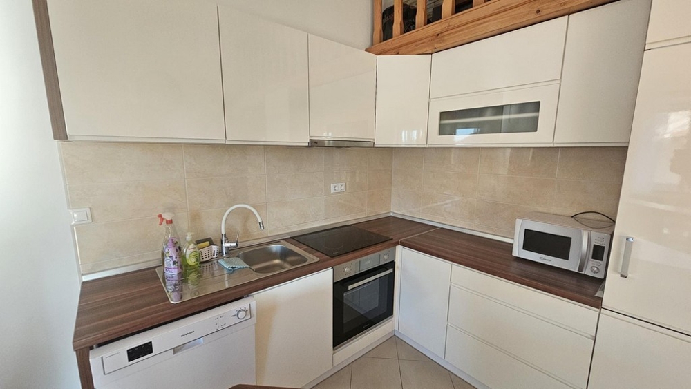 Moderne zariadená kuchyňa s elektrospotrebičmi a pracovnou doskou